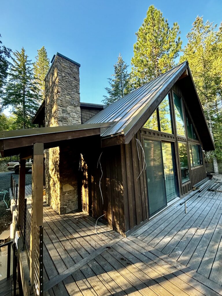 Rustic wood cabin with a stone fireplace and metal roofing Cedar