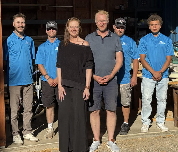 Group photo of a construction team in front of a workshop.